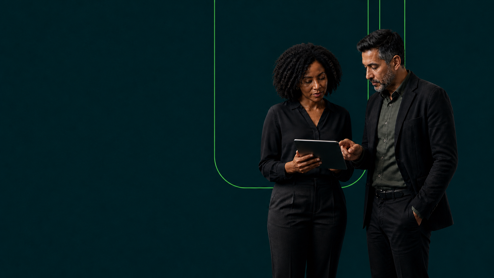 Two senior technology professionals standing together and discussing a digital platform on a tablet